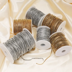 Golden and silver stainless steel box chain rolls for DIY jewelry making on silk fabric