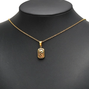 Golden rectangular shell pendant necklace with olive branch motif on black bust display