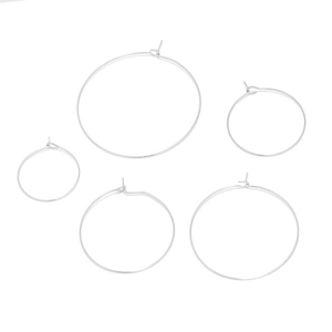 Detailed set of five minimalist silver hoop earrings in varying sizes on white background