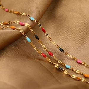 Golden stainless steel flattened chain with colorful enamel lips charms on silk fabric