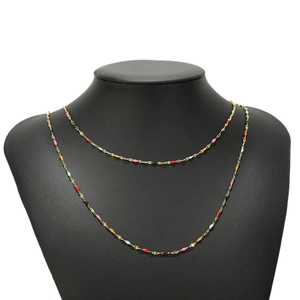 Detail of gold-plated stainless steel cross chain with colorful enamel lip-shaped charms