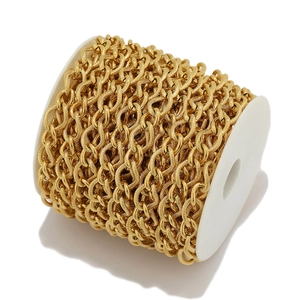 Macro shot of gold stainless steel thick curb chain wrapped on white spool for DIY jewelry