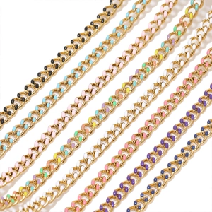 Detailed macro of colorful enamel drip finish on golden stainless steel cuban link chains