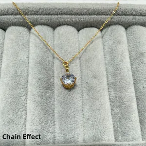 Detail showing the 7mm round zircon pendant with gold chain on grey velvet tray