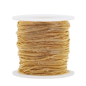 Macro detail of 1.8mm golden 18k plated stainless steel Cuban chain on a white spool