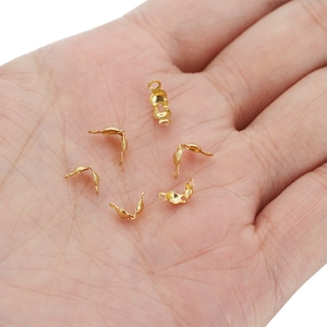 Golden stainless steel fold-over cord ends for jewelry making shown in hand palm