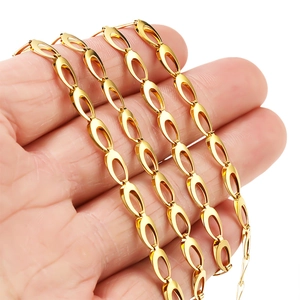 Golden 5mm stainless steel hollow oval link chain held by hand on white background