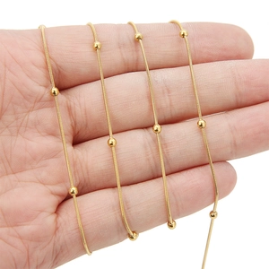 Detail van 18 karaat vergulde slangketting met kleine gepolijste metalen kralen