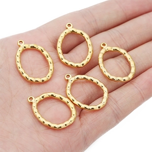 Fünf goldene Hammerschlag-Anhänger aus 18k vergoldetem Edelstahl auf einer Hand