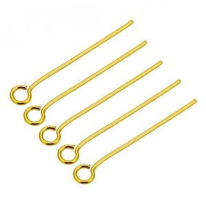 Close-up of five gold-plated stainless steel eye pins for jewelry making and DIY crafts