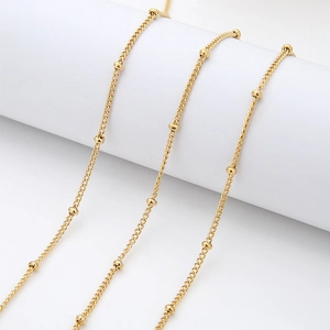Detail of 18K gold plated stainless steel satellite chain with small beads on a white roll