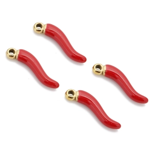 Detailopname van rode emaille chili peper hangers met gouden ringen op witte basis