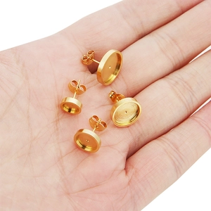 Golden stainless steel stud earring bases in four sizes held on a hand for DIY jewelry