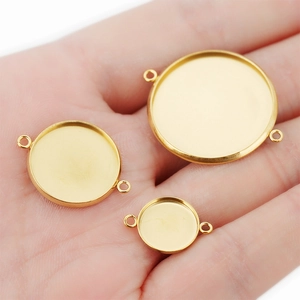 Three gold polished stainless steel circular pendant trays in varying sizes on a palm
