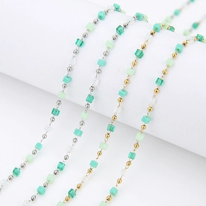 Detailed macro view of green crystal cube beads with metallic spacers on DIY chains