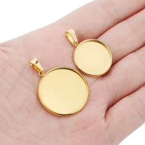 Golden stainless steel round pendant trays for DIY jewelry making on human palm for scale