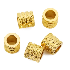 Makro-Detail von 18k vergoldeten Edelstahlperlen mit gerändelter Rauten-Textur