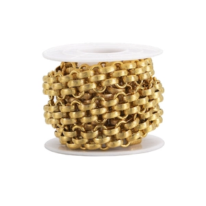 Detail of 13mm gold plated braided curb chain with textured surface on a spool