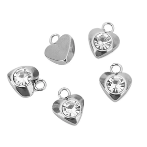 Detalle de cinco colgantes de corazón en acero inoxidable plateado con diamantes