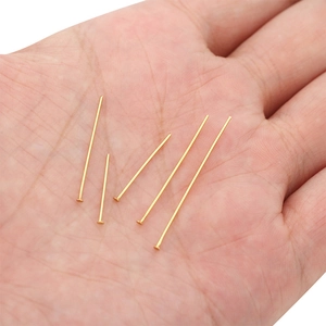Spilli a T in acciaio inox placcato oro per gioielli fai-da-te mostrati sul palmo per misura