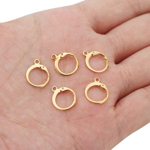 Five gold leverback earring hooks with open loops held in hand for size visualization