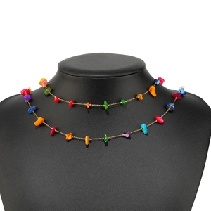 Bohemian style golden necklace with colorful irregular beads on black mannequin