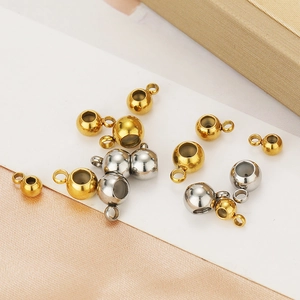 Macro shot of 18K gold and silver plated stainless steel slide beads with loop for DIY jewelry
