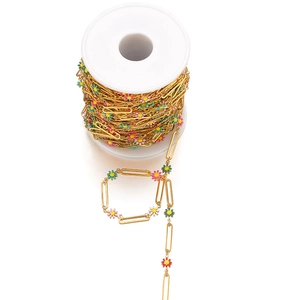 Detail of 18k gold paperclip chain with colorful enamel daisies on a white spool