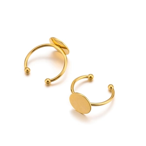 Close-up of golden stainless steel adjustable ring bases with round flat trays for DIY jewelry