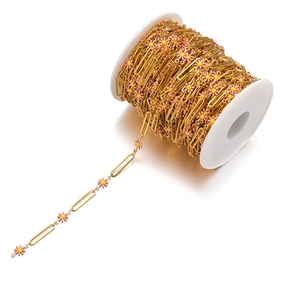 Close-up of 18k gold-plated daisy flower chain on a white spool for DIY jewelry making