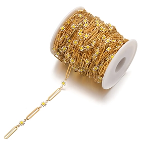 Macro shot of 18k gold plated paperclip chain with white daisy enamel charms for DIY