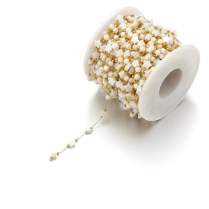 Detail of 18k gold plated 8mm shell star and bead chain on white spool for jewelry making