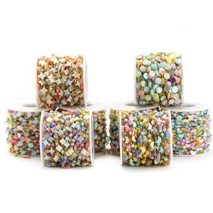 Close-up of colorful heart and star shell beads on metal chains for DIY jewelry making