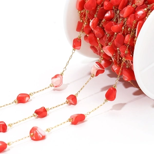 Macro detail of 4mm irregular red shell beads with gold chain for DIY jewelry making