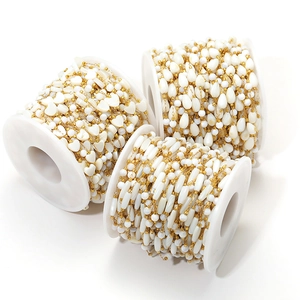 Close-up of heart and teardrop shell bead chains on spools for DIY jewelry making