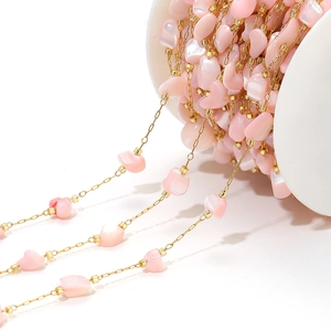 Macro detail of 4mm pink shell petal beads on a gold DIY necklace jewelry chain