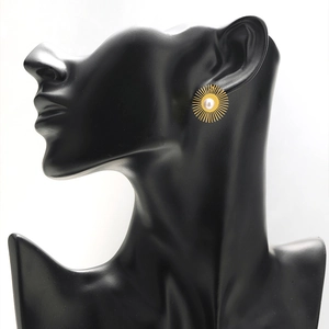 Vintage 18k gold sunflower earrings with white pearl center on a black jewelry bust
