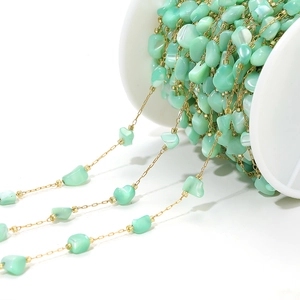 Macro view of 4mm mint green shell beads on golden chain for DIY jewelry making
