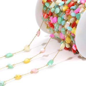Macro detail of 4mm colorful irregular shell beads on golden DIY jewelry chains
