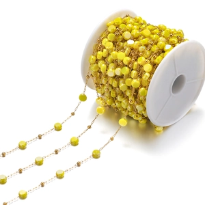 Detalle de cadena de cuentas de vidrio amarillo con eslabones dorados para crear joyas