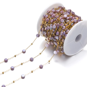 Detalle de cuentas de cristal morado en cadena dorada para creación de joyas de bricolaje