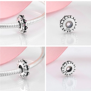 Macro shot of S925 sterling silver charms with zircon inlay and engraved material stamp