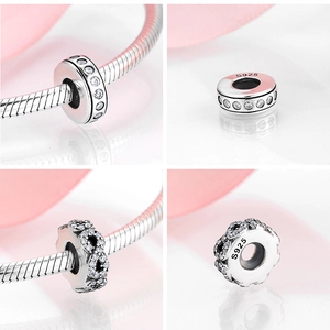 Detail of S925 sterling silver bead charms with zircon inlay and engraved purity hallmark