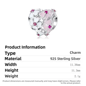 Vue macro d'un charm cœur en argent S925 avec fleurs en émail rose et pierres fines
