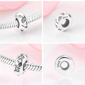 Détail macro du charm en argent S925 avec pierres roses et inscription Love gravée