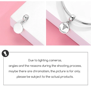 Detailed macro view of S925 sterling silver medical charm with caduceus and engraving
