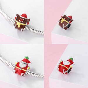 Detail of Christmas reindeer and Santa charms with vibrant red enamel on a silver bracelet