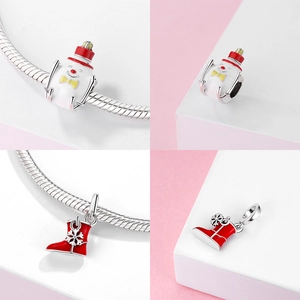 Macro detail of S925 sterling silver Christmas snowman bead and red boot charm for bracelet