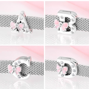 Macro view of 925 sterling silver charms with pink enamel bows and sparkling zircons