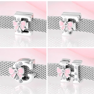 Detailed macro view of 925 silver alphabet charms E F G H with pink enamel bows and zircons